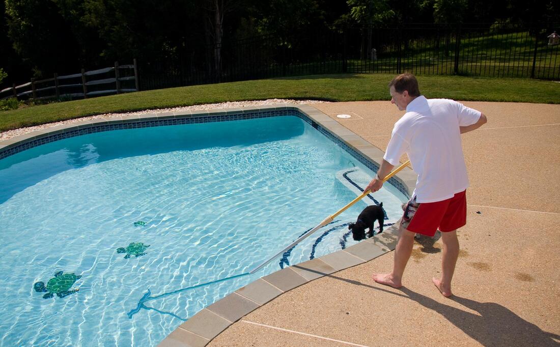man cleaning out the pool